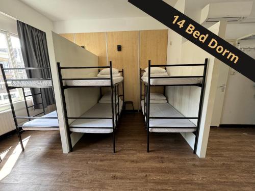 a dorm room with three bunk beds in it at Xplore Hostel Amsterdam in Amsterdam