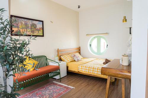 a bedroom with a bed and a chair and a table at NẮNG House in Da Nang