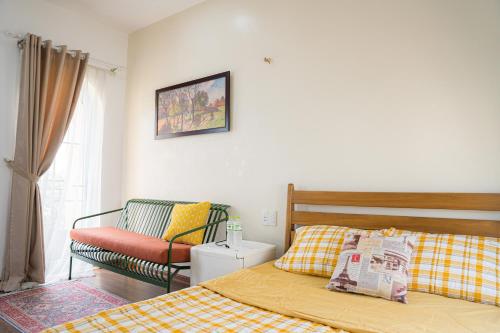 a bedroom with a bed and a couch and a chair at NẮNG House in Da Nang