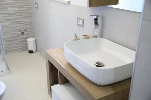 La salle de bains est pourvue d'un lavabo blanc et d'une douche. dans l'établissement Scavi di Pompei - Intero appartamento max 6 persone - Pompeii Getaway, à Scafati