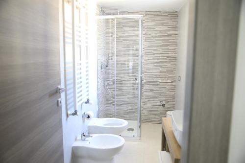 a bathroom with two sinks and a glass shower at Pompeii Getaway - Scavi di Pompei - Intero appartamento max 6 persone a 5 min dal centro in Scafati