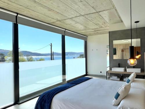 una camera con un grande letto e una grande finestra di Hospedium Hotel Devalar Do Mar a Camariñas