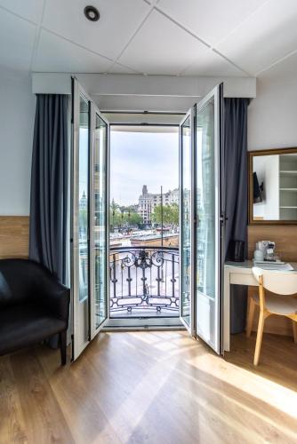 a room with a balcony with a desk and a window at Venecia Plaza Centro in Valencia
