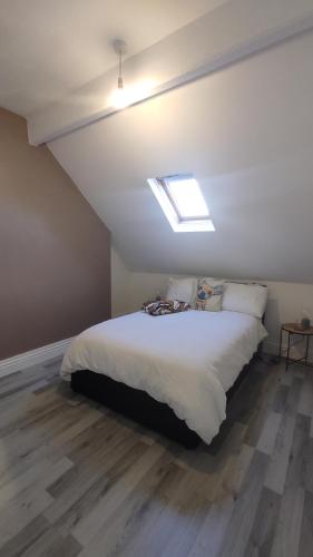 a bedroom with a large white bed with a skylight at CASA JIMENEZ - Close to town with Shared bathroom in Cardiff