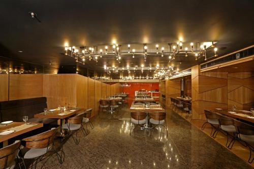 a restaurant with tables and chairs and a chandelier at The Ornate in Guwahati