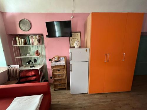 kuchnia z białą lodówką i pomarańczową szafką w obiekcie Corona Grossa - due posti letto - B w mieście Brusasco