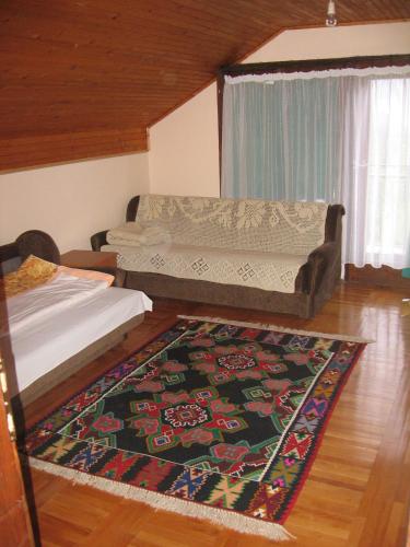 a living room with a couch and a rug at Guest house Pribojska Banja in Pribojska Banja
