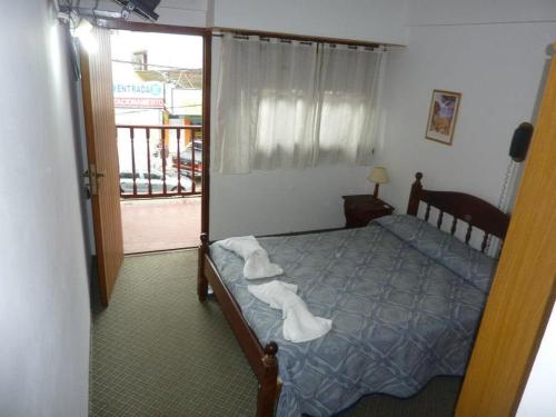 1 dormitorio con 1 cama con toallas en Hotel Dos Reyes en Villa Gesell