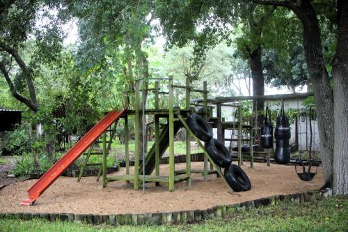 a playground with a red slide in a park at Kruger Park Farmstay near Orpen Gate in Hoedspruit