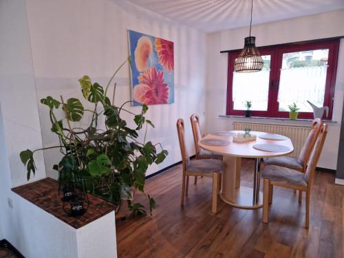 ein Esszimmer mit einem Tisch und einer Topfpflanze in der Unterkunft Ferienwohnung ca.80qm in Lebach