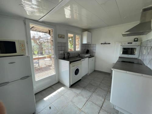 une cuisine blanche avec un lave-linge et un sèche-linge. dans l'établissement Cabanon provencal Verdon, à Aups