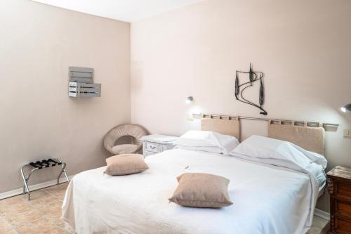 a bedroom with a white bed with two pillows on it at Il risveglio del Poggio in Castiglione dʼOrcia