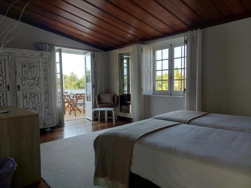 a bedroom with a bed and a view of a patio at Vila Louro in Santa Cruz