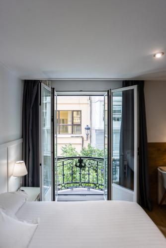 a bedroom with a large bed and a balcony at Venecia Plaza Centro in Valencia