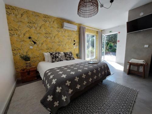 a bedroom with a bed and a yellow wall at Vila Louro in Santa Cruz