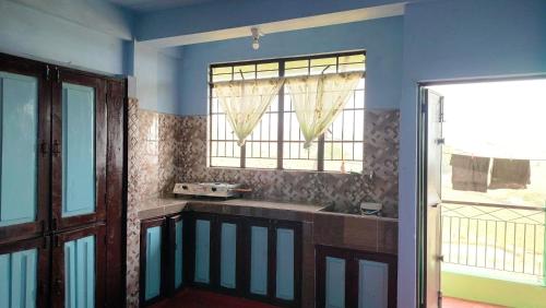 una cucina con lavandino e finestra di GREEN HILLS a Cherrapunji