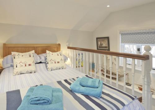 a bedroom with a bed with blue towels on it at Pilot Cottage in Southwold