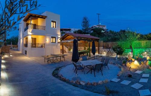 Un patio con una mesa y sillas frente a una casa. en Anelia Serene Villa, en Sfakaki