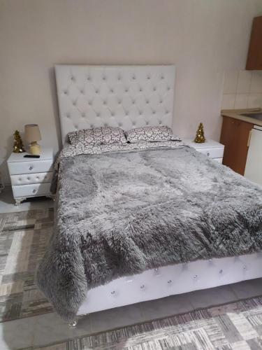 a bedroom with a large bed and two night stands at ΣΕΤΣΚΟΣ ΖΗΣΗΣ in Kato Loutraki