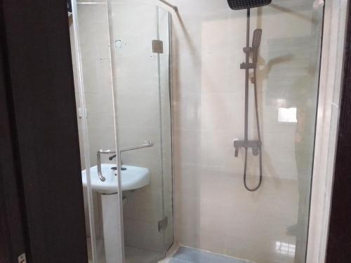 uma casa de banho com um lavatório e um chuveiro em st Theresers apartment B2 em Lekki