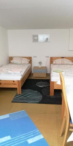 a room with two beds and a table and chairs at Vermietung Gisl in Wiesent