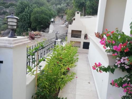 balcón con flores y barandilla blanca en Genç Apart, en Muğla