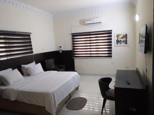 a hotel room with a bed and a table and a desk at st Theresers apartment B2 in Lekki