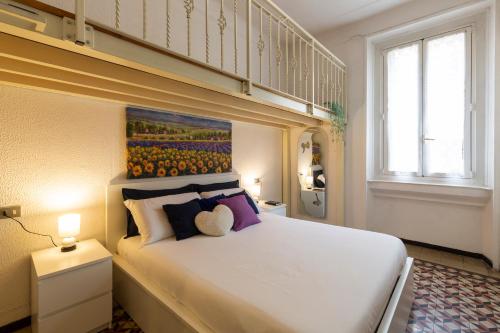 een slaapkamer met een groot wit bed met paarse kussens bij Titty House - Crocetta in Milaan
