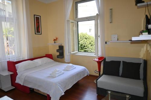 a bedroom with a bed and a chair and a window at Apartment King in Opatija