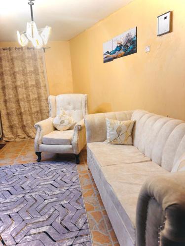Haven homes في Kiambu: غرفة معيشة مع أريكة وكرسي