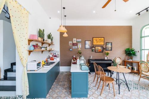a kitchen with blue cabinets and a table and chairs at NẮNG House in Da Nang