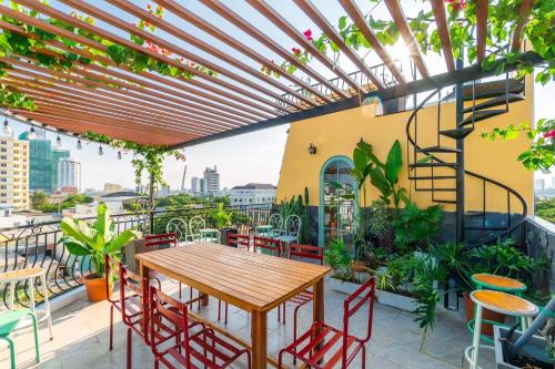 an outdoor patio with a wooden table and chairs at NẮNG House in Da Nang