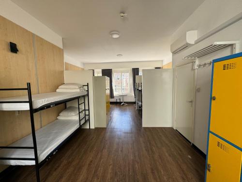 a dorm room with bunk beds and a hallway at Xplore Hostel Amsterdam in Amsterdam