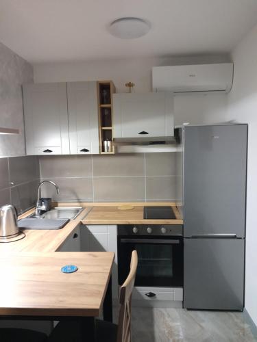 a kitchen with a stainless steel refrigerator and a wooden table at Nemanjina Centar in Pančevo