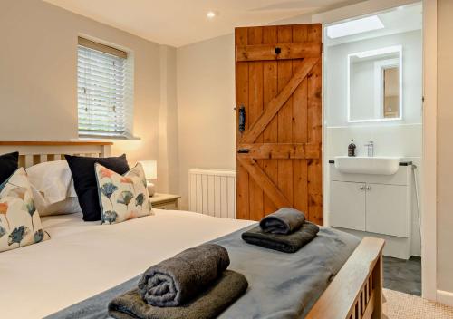a bedroom with a bed with towels on it at Dolphin Cottage in Wiveton