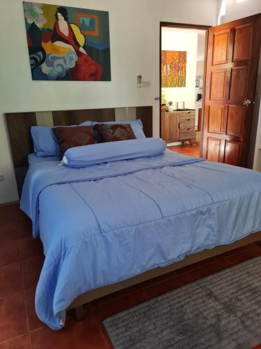 Schlafzimmer mit einem großen Bett mit blauer Decke in der Unterkunft Grand Luxe Kamala in Kamala Beach