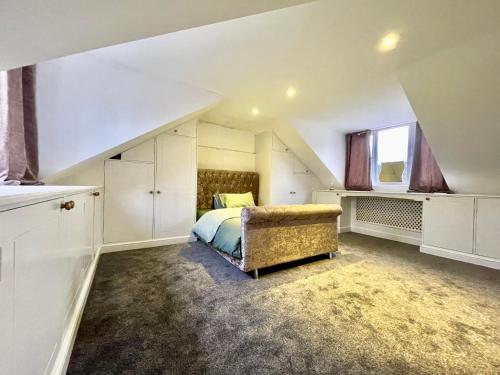 an attic bedroom with a bed and a chair at Aldridge in Chipstead