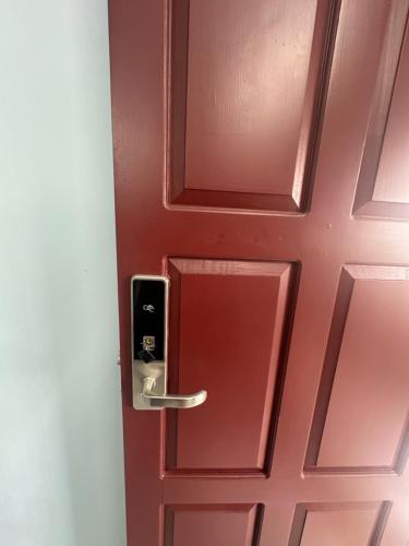 a red door with a silver door handle at Thaliath Inn Varapuzha in Ernakulam