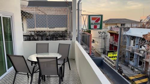 a patio with a table and chairs on a balcony at Blue whale Hostel & Café in Pattaya Central