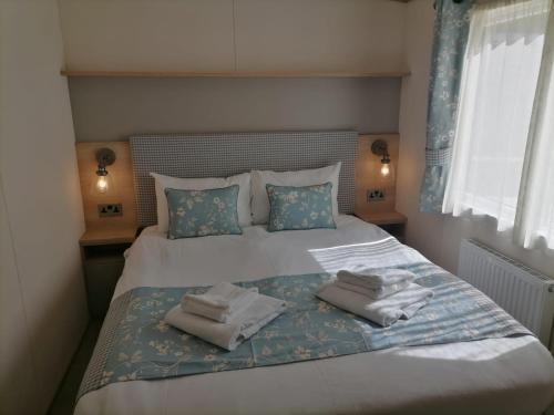 um quarto com uma cama com toalhas em The Willows - 3 bedrooms with enclosed decking em Fairlight