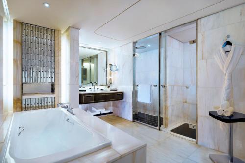 a bathroom with a tub and a shower and a sink at The St. Regis Shenzhen in Shenzhen