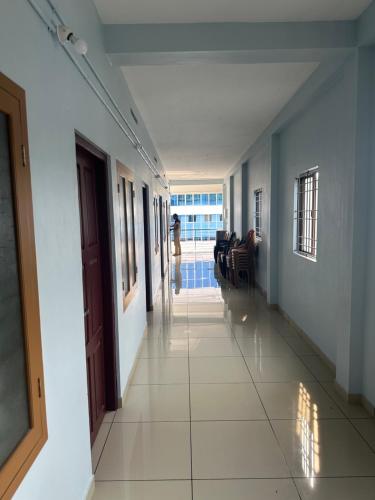 a hallway of a house with a person walking in the distance at Thaliath Inn Varapuzha in Ernakulam
