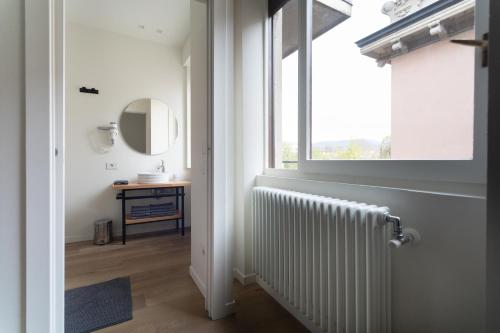 baño con radiador y ventana en RGA Bergamo House, en Bérgamo