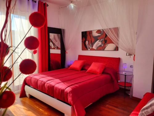 ein Schlafzimmer mit einem roten Bett mit roten Kissen in der Unterkunft Charme e Benessere in home suite in Portici