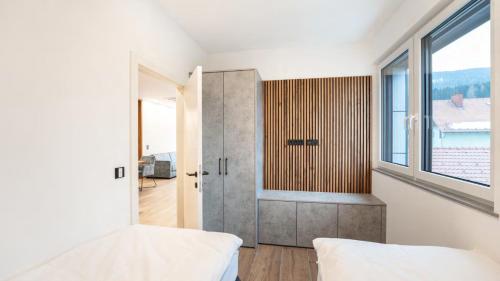 a bedroom with white walls and a large window at Arbio Penthauser-Lorenzerhof in Murau