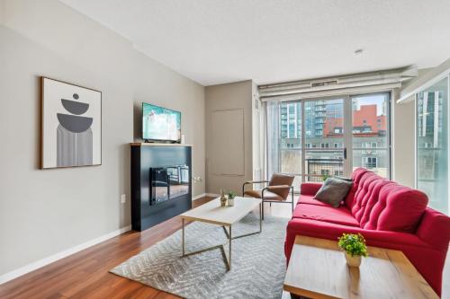 a living room with a red couch and a tv at CozySuites Mill District with gym # 10 in Minneapolis
