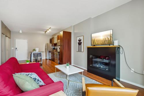a living room with a red couch and a fireplace at CozySuites Mill District with pool, gym # 10 in Minneapolis