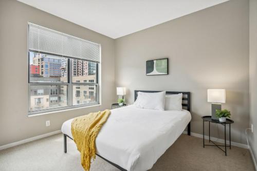 a bedroom with a large white bed and a window at CozySuites Mill District with gym # 10 in Minneapolis