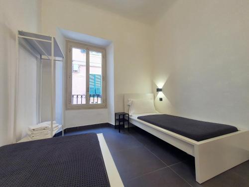 um quarto com 2 camas e uma janela em Sant'Agostino XXXII em La Spezia