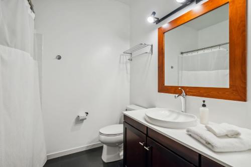 a white bathroom with a sink and a mirror at CozySuites Mill District pool gym # 10 in Minneapolis